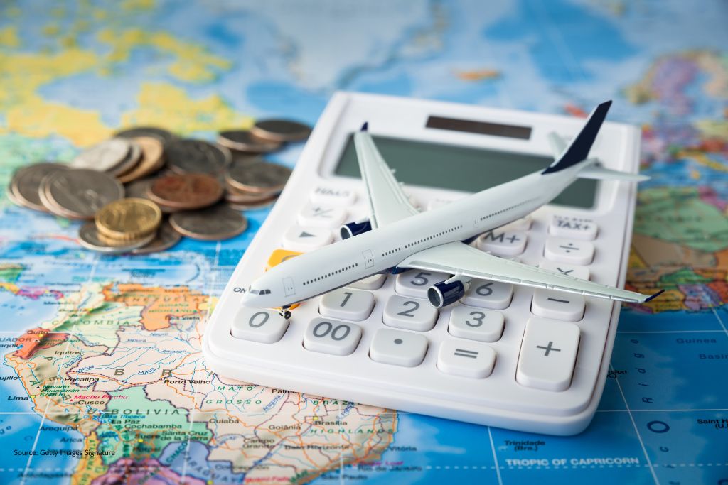 picture of a model plan sitting on a calculator, both sitting on a map of the world